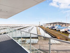 Ein Yachthafen mit vertäuten Booten, einem überdachten Steg und einem Gebäude im Hintergrund.