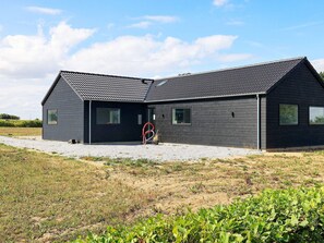 A modern two-story building with a sloped roof and a gravel driveway. - 5 Star Holiday Home in Bogense (Bogense)