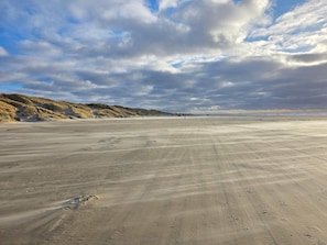 A wide sandy beach with dunes in the background and a partly cloudy sky. - 4 Star Holiday Home in Lokken (Lokken)