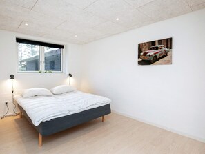 A bedroom with a bed, a window, and a wall-mounted picture. - 4 Star Holiday Home in Lokken (Lokken)