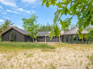 A modern house with a large window and a swing set in the yard. - 4 Star Holiday Home in Lokken (Lokken)