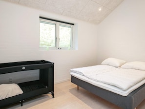 A bedroom with a bed, a black bench, and a window. - 4 Star Holiday Home in Lokken (Lokken)