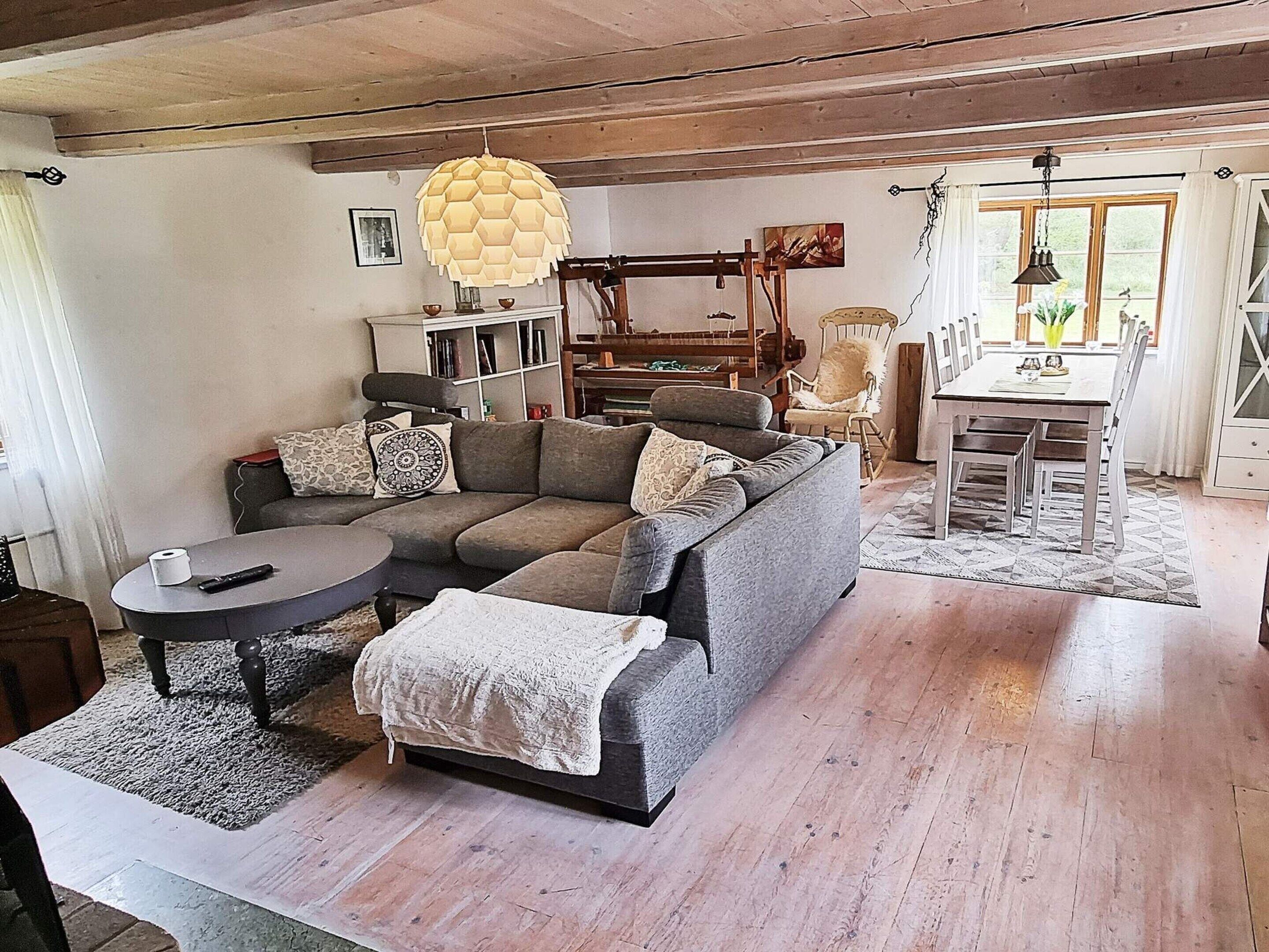 Un salón acogedor con un sofá modular, una mesa redonda de centro y un comedor con mesa y sillas.