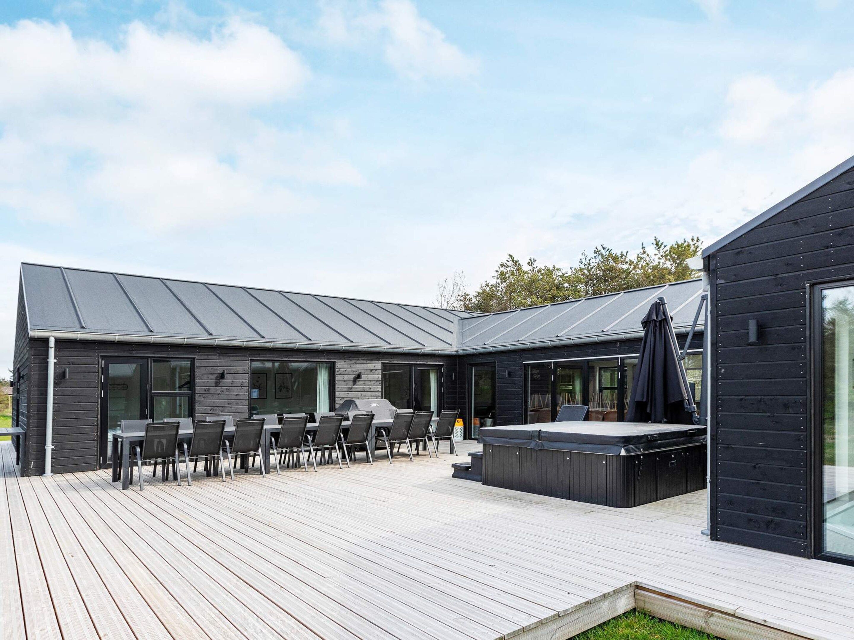 Une terrasse extérieure moderne dotée d’un jacuzzi, d’un espace salon et d’un patio couvert.
