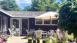 A house with a patio, outdoor seating, and a garden. - 6 Person Holiday Home in Tisvildeleje (Tisvildeleje)