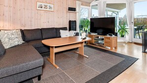 Una sala de estar moderna con un sofá, una mesa de centro y un televisor.