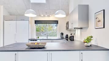 Una cocina moderna con una isla grande, electrodomésticos integrados y un ventanal con vistas.
