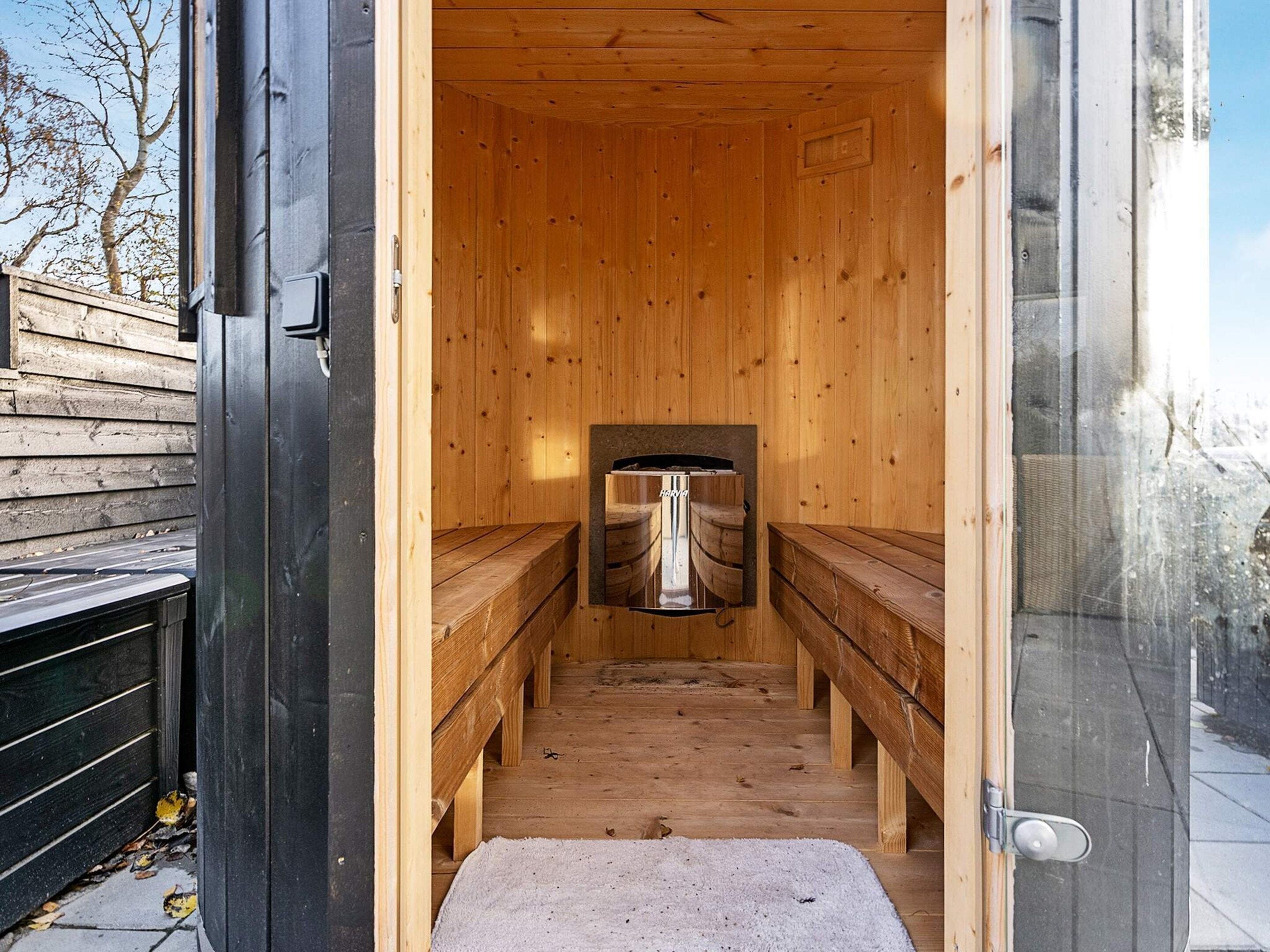 Una sala de sauna con bancos y un equipo de sauna.
