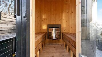 Una sala de sauna con bancos y un equipo de sauna.