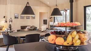 A dining area with a fruit and bread display, a dining table, chairs, and pendant lighting. - 5 Star Holiday Home in Albaek (Aalbaek)