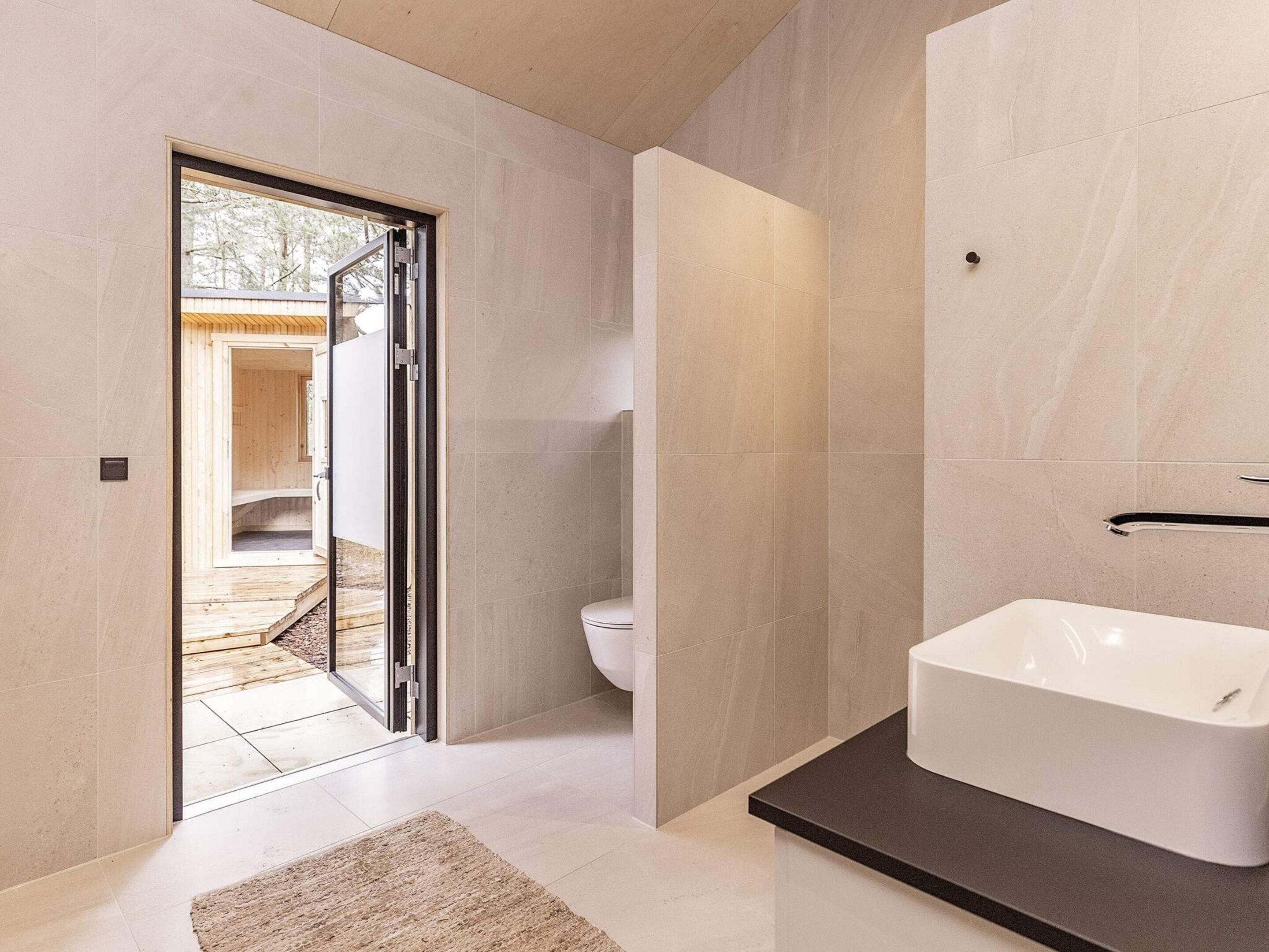 Ein modernes Badezimmer mit Badewanne, Toilette und Duschbereich.