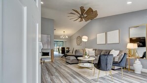 A modern living room with a grey sofa, a coffee table, and a ceiling fan.