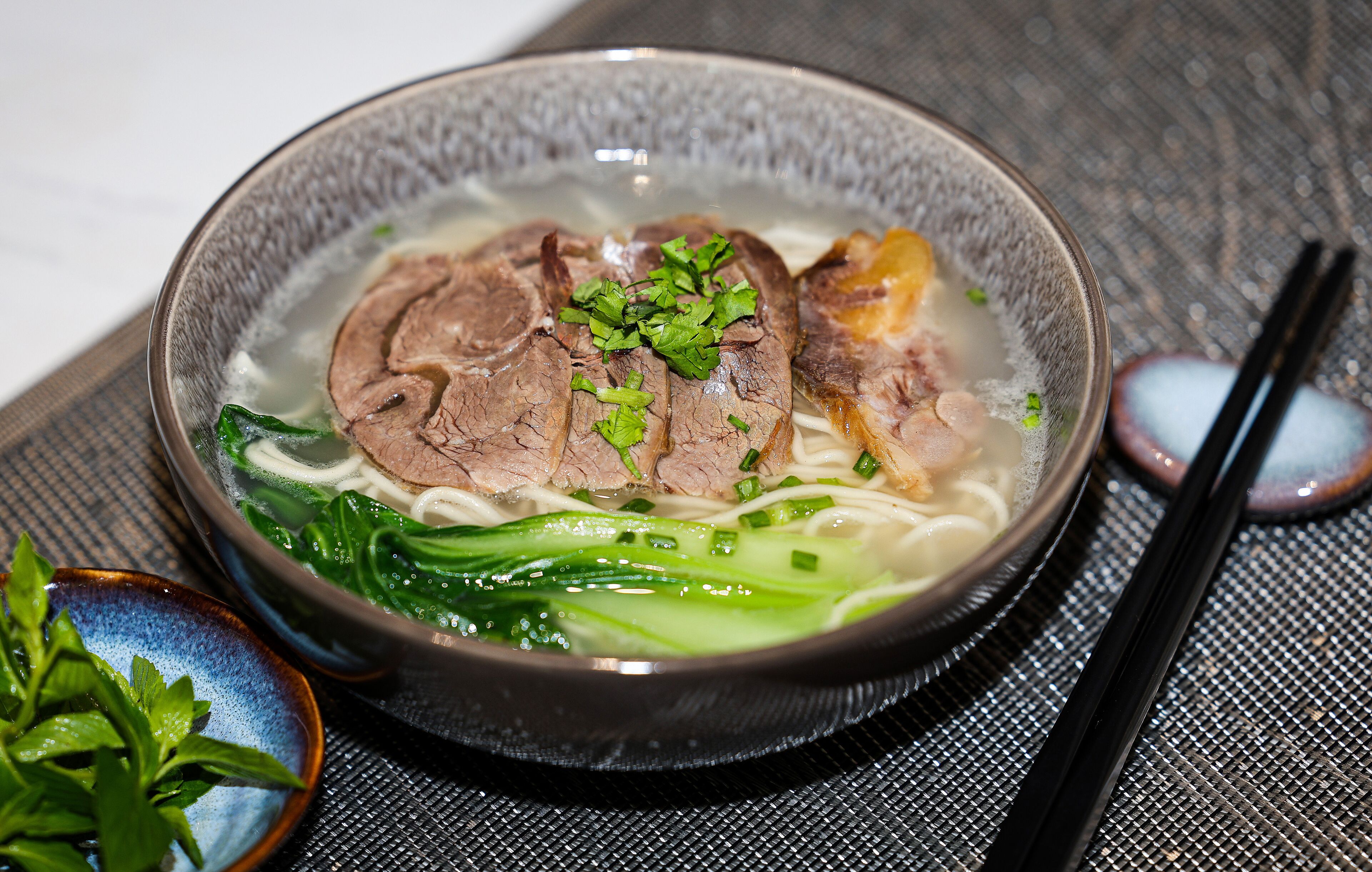 A bowl of soup with meat and vegetables.