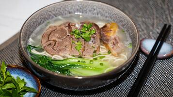 A bowl of soup with meat and vegetables.