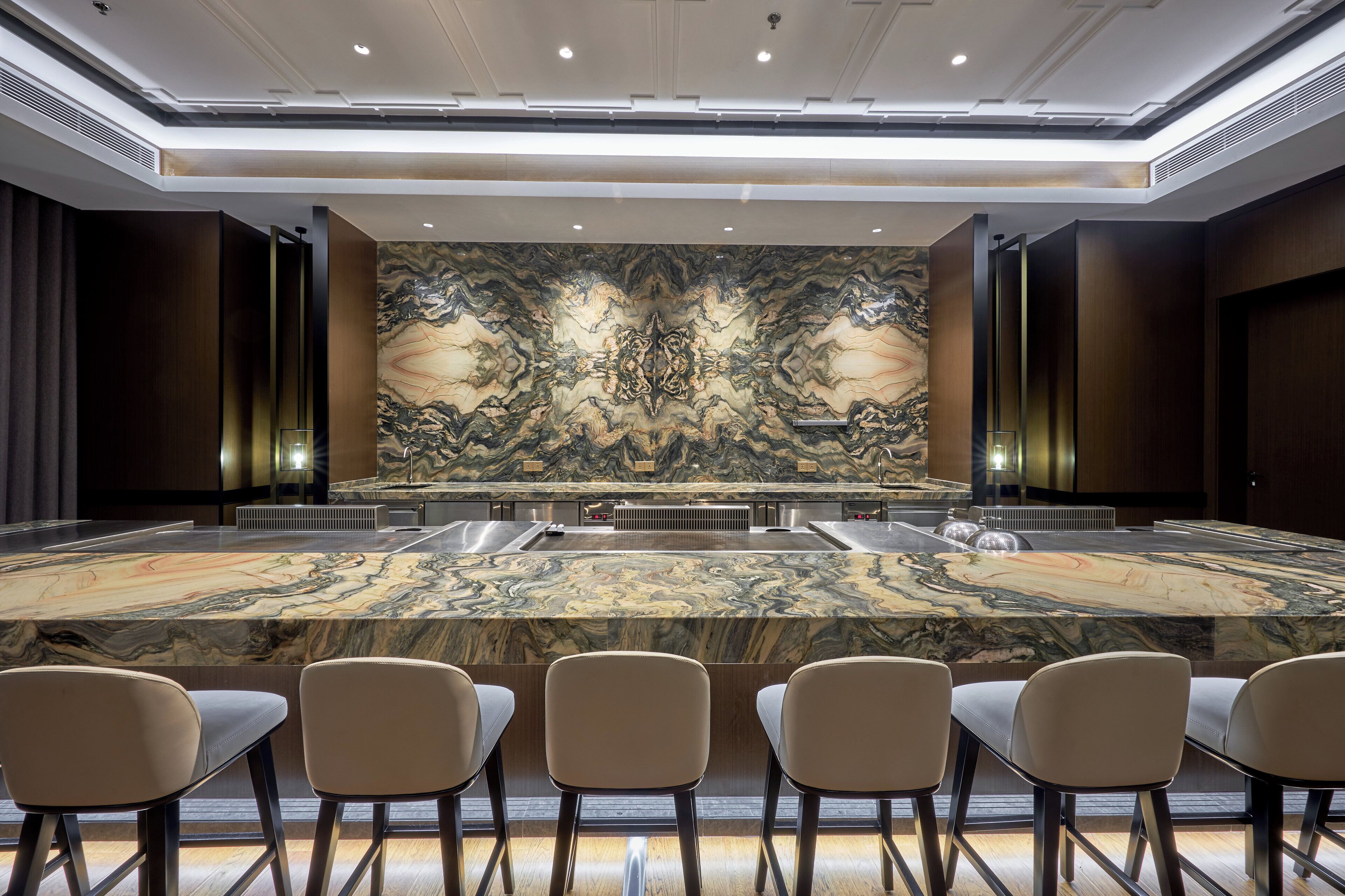 A conference room with a large marble table, six chairs, and a decorative wall mural.