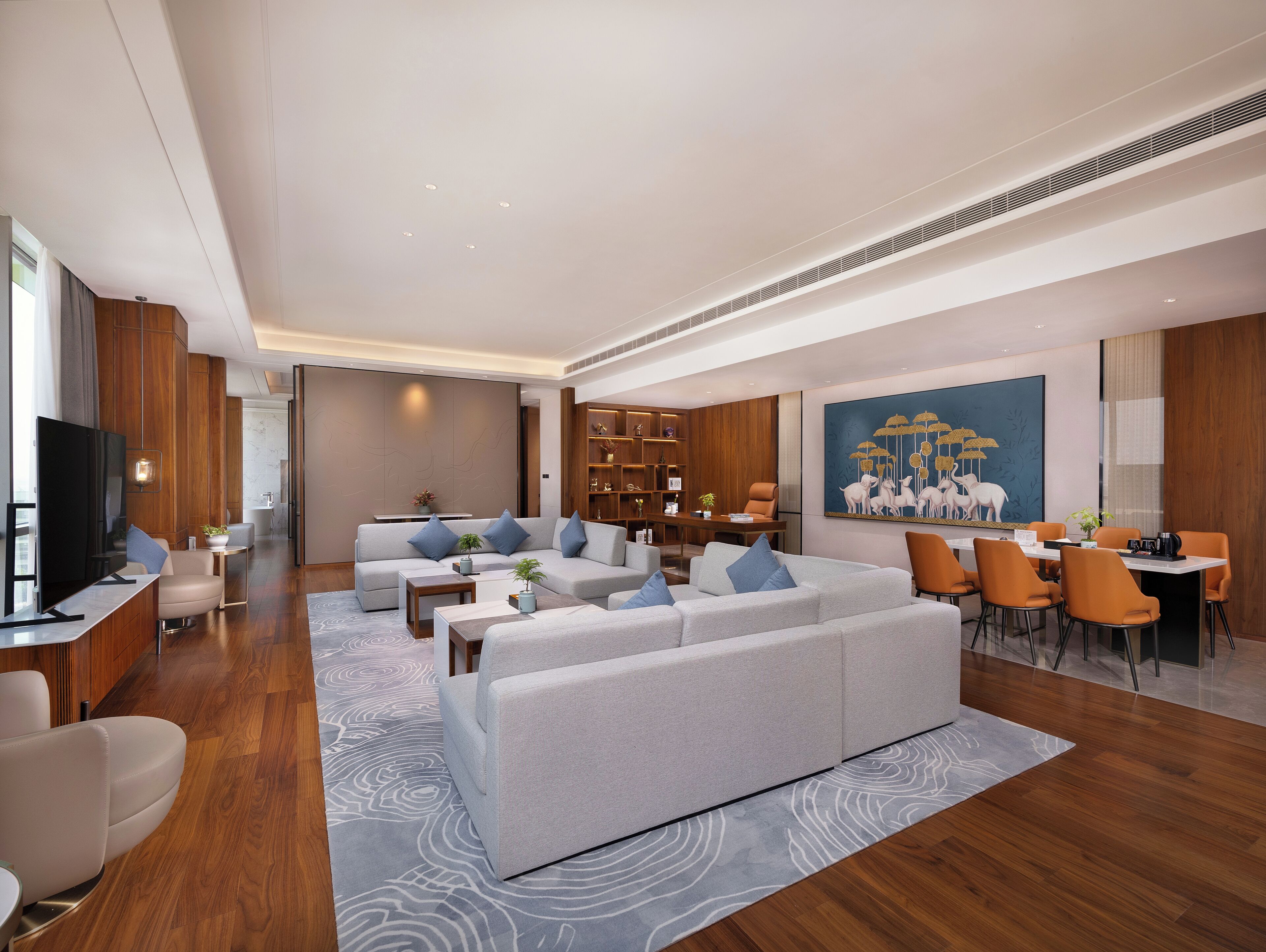 A modern living room with a sofa set, a dining area, and a TV.