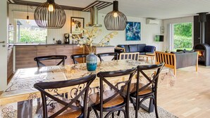 A modern kitchen with a large island, pendant lighting, and a view of the outdoors. - 7 Person Holiday Home in Dannemare (Dannemare)