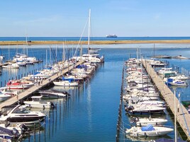 Un puerto deportivo con numerosas embarcaciones amarradas a muelles de madera.