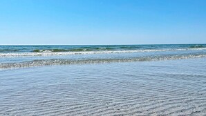 A beach with clear skies and calm waves.