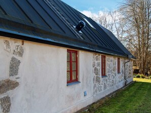A stone building with a sloped roof and red-framed windows. - 4 Person Holiday Home in Skurup (Skurup)