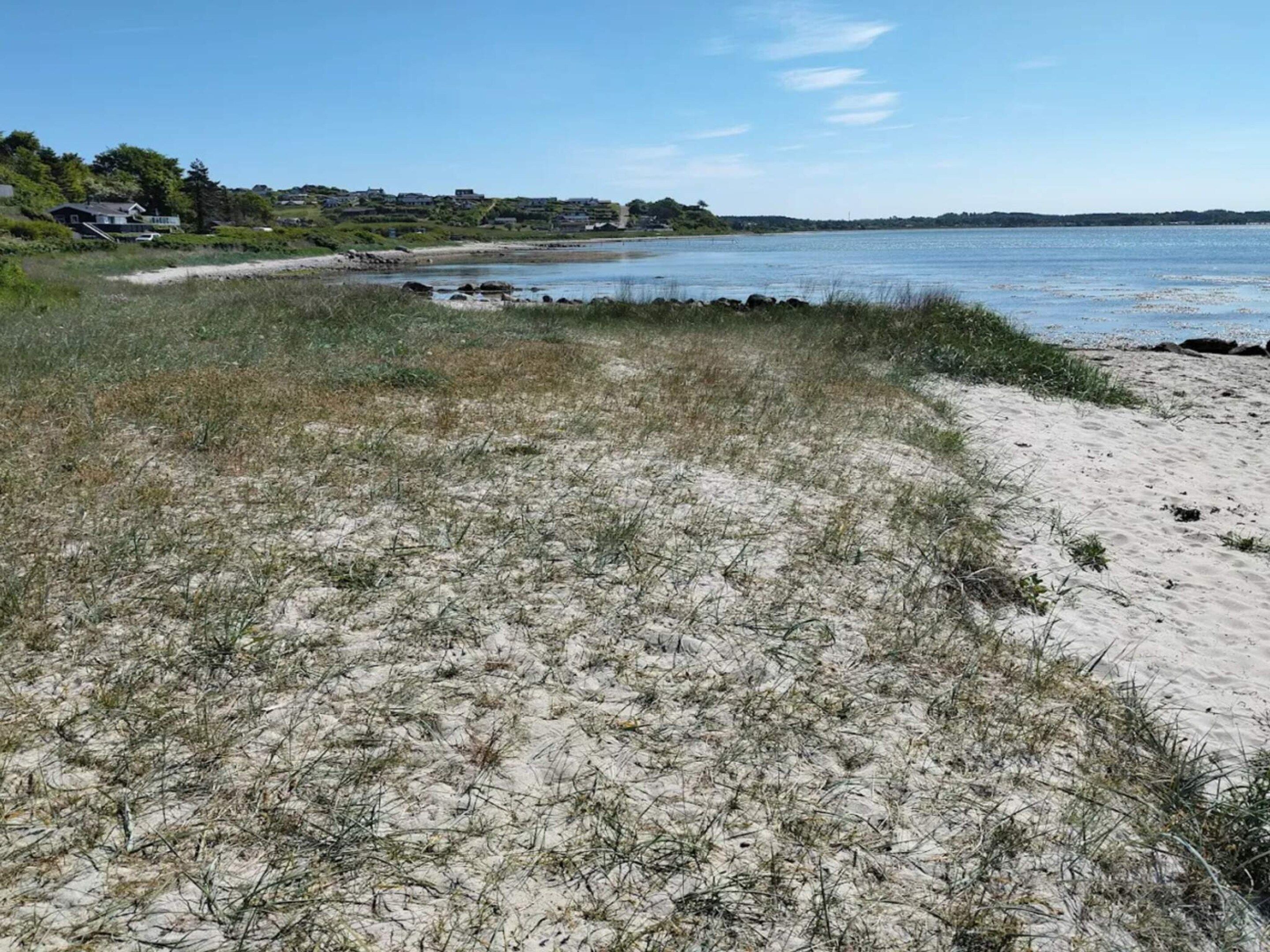 A beach with sand dunes and a clear view of the water.