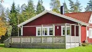 En röd byggnad med en överbyggd veranda och en skorsten.