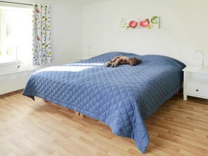 A bedroom with a bed, a nightstand, a window with curtains, and a wall decoration. - 4 Person Holiday Home in Bralanda (Bralanda)