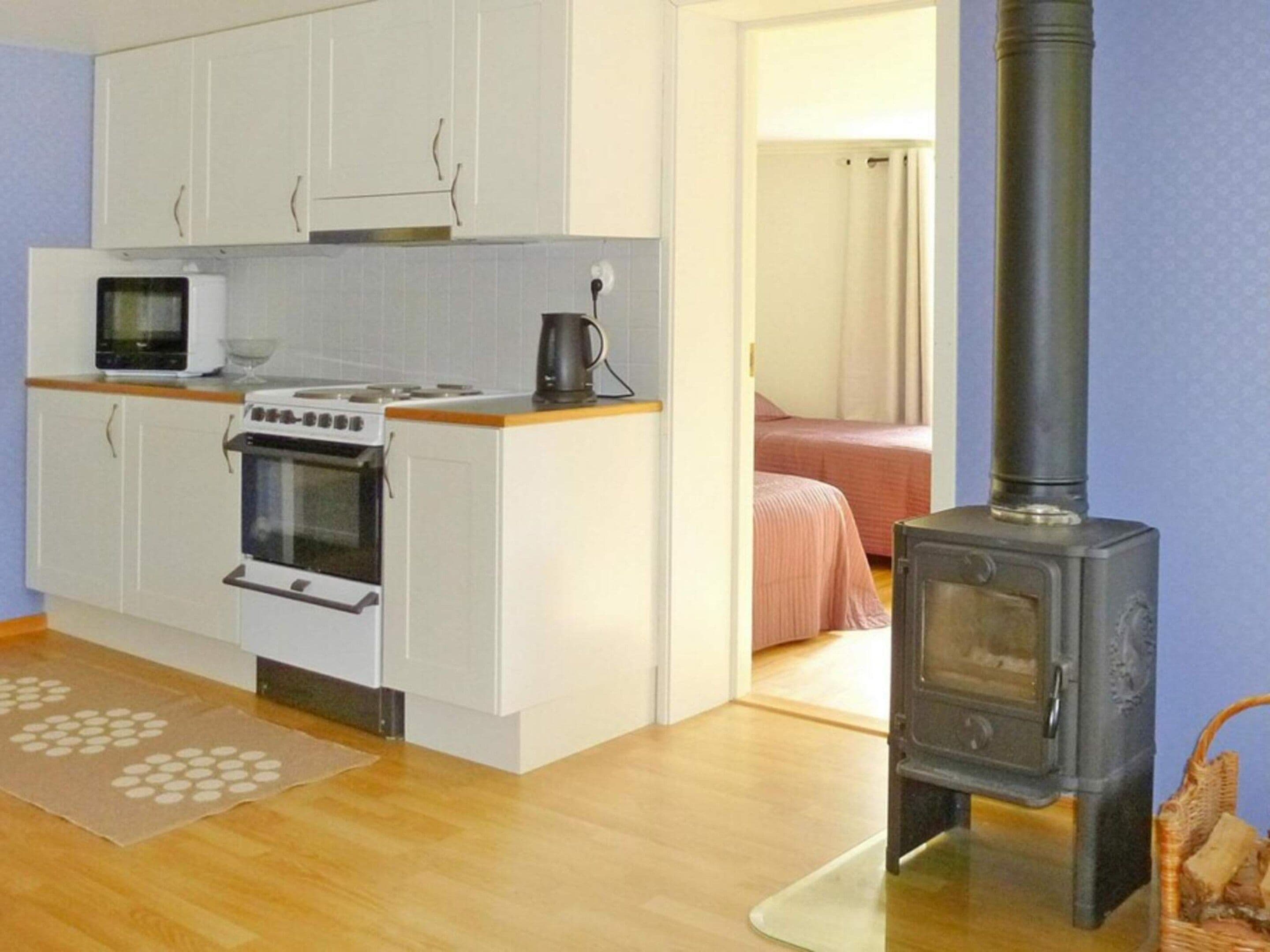 A compact kitchen with a stove, microwave, and cabinets.