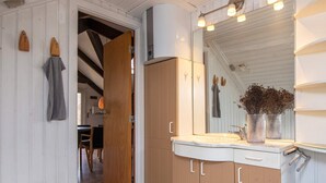 A modern bathroom with a large mirror, wooden cabinets, and a marble sink. - 6 Person Holiday Home in Ebeltoft (Ebeltoft)
