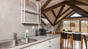 A kitchen with a large island, a built-in wine rack, and a dining area with a table and chairs. - 6 Person Holiday Home in Ebeltoft (Ebeltoft)