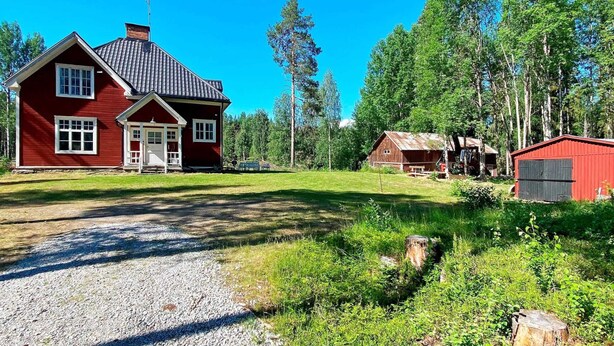 A red house with a gravel driveway and a wooden deck. - 8 Person Holiday Home in Lycksele-by Traum (Kattisavan)