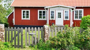 A red wooden house with a tiled roof, white windows, and a white door. - 8 Person Holiday Home in Kopingsvik (Kopingsvik)