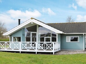 A single-story house with a gabled roof, large windows, and a white porch railing. - 4 Star Holiday Home in Hadsund (Hadsund)