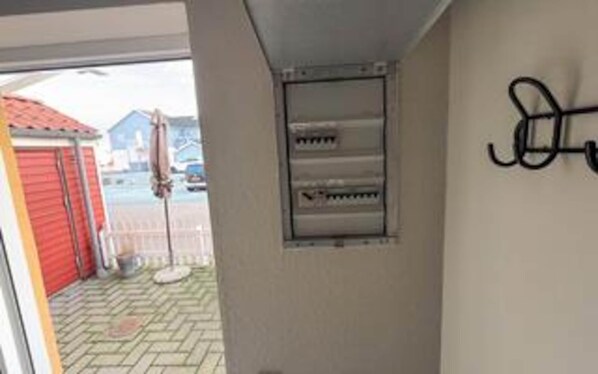 A room with a window, a door, and a wall-mounted air conditioning unit.