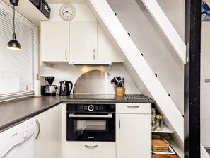 A modern kitchen with white cabinetry, a Bosch dishwasher, and a coffee maker. - 4 Star Holiday Home in Vaeggerlose (Vaeggerlose)