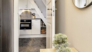 A compact kitchen with white cabinets, a Bosch oven, and a small potted plant on a wooden table. - 4 Star Holiday Home in Vaeggerlose (Vaeggerlose)