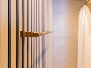 A modern bathroom with vertical striped walls and a shower curtain.
