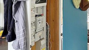 A room with a blue wall, a wooden door, and a white electrical panel. - 5 Person Holiday Home in Aabenraa (Aabenraa)