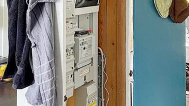 A room with a blue wall, a wooden door, and a white electrical panel. - 5 Person Holiday Home in Aabenraa (Aabenraa)