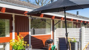 An outdoor patio with a table, chairs, a grill, and a covered area. - 5 Person Holiday Home in Aabenraa (Aabenraa)