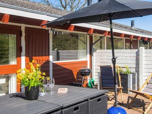 An outdoor patio with a table, chairs, a grill, and a covered area. - 5 Person Holiday Home in Aabenraa (Aabenraa)