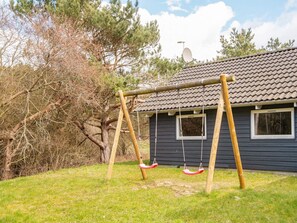 A house with a swing set in the yard.
