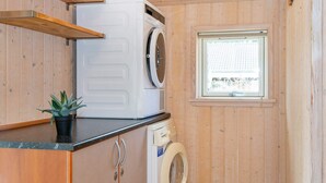 A compact laundry room with a washing machine, dryer, and a small window.