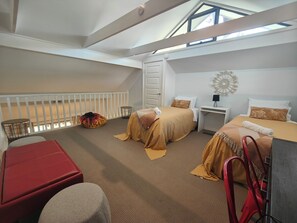A spacious room with a high ceiling, a loft bed, a desk, and a small seating area. - Blue Lago at Raffertys Resort (Cams Wharf)