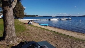 A lakeside view with a dock, boats, and a picnic area. - Blue Lago at Raffertys Resort (Cams Wharf)