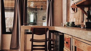 Una cucina rustica con mobili in legno, un'isola centrale con una sedia, luci a sospensione e un forno a microonde.