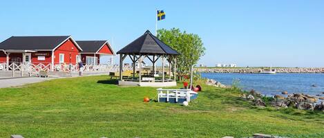 A coastal area with a red building labeled 'INSEGLET,' a gazebo, and a fenced playground.