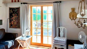 A room with a wooden door, a desk, a chair, a lamp, a fan, and a decorative skull on the ceiling. - 6 Person Holiday Home in Soderakra (Soderakra)