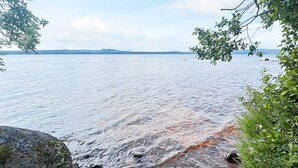 A natural landscape with a rocky shoreline and calm water. - 4 Person Holiday Home in Braas (Braås)