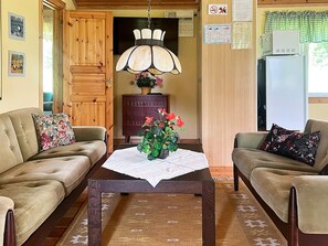 A cozy living room with two sofas, a wooden coffee table, and a hanging lamp. - 4 Person Holiday Home in Braas (Braås)